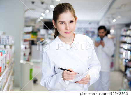 pharmacist carefully keeps a re-inventory of medicines pharmacist carefully keeps a re-inventory of medicines 40342730