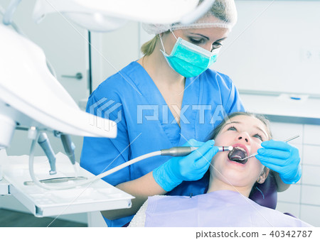 Female dentist treating girl 40342787