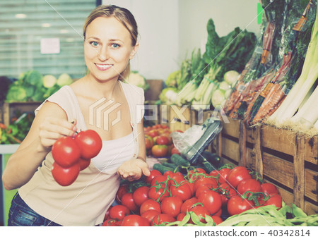 Portrait of woman buying organic tomatoes in shop 40342814