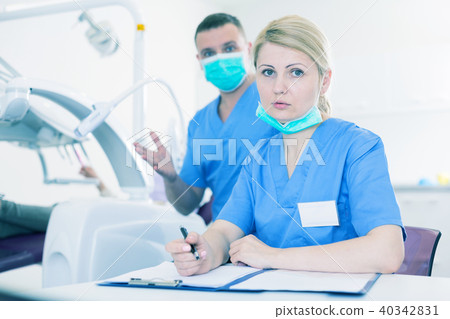Female stomatologist recording diagnosis 40342831