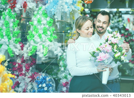 Couple choosing trendy flower decoration in store Couple choosing trendy flower decoration in store 40343013