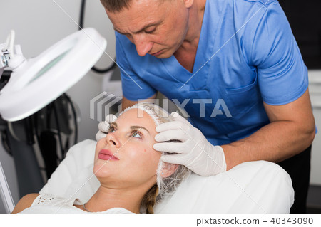 Doctor is examining woman patient before the procedure 40343090