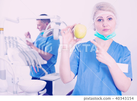 Woman dentist pointing at apple 40343154