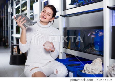 teenager selecting interesting aquarium rocks and stone for aquarium entourage 40343406