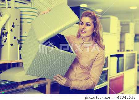 Young woman choosing soft pouf in modern home furnishings store Young woman choosing soft pouf in modern home furnishings store 40343535