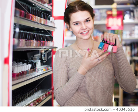 female customer looking for nail polish in cosmetics shop female customer looking for nail polish in cosmetics shop 40343536