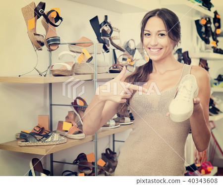 Female customer showing desired shoe in boutique 40343608