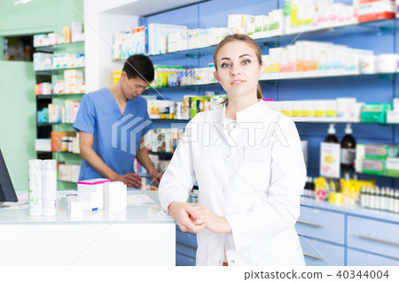 specialist standing near table with cashbox in pharmacy. 40344004