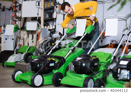 Shopper is looking with interest the lawnmower 40344112