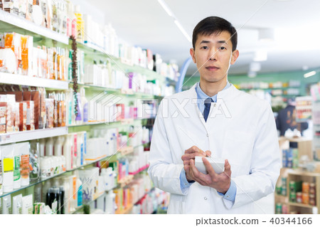 male pharmacist is inventorying medicines 40344166