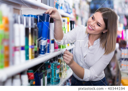 young woman choosing haircare products at store 40344194