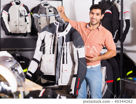 Man is demonstrating new jacket for motorbike in the store. Man is demonstrating new jacket for motorbike in the store. 40344262