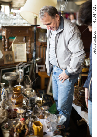 Adult man is looking old things at the fleamarket Adult man is looking old things at the fleamarket 40344323