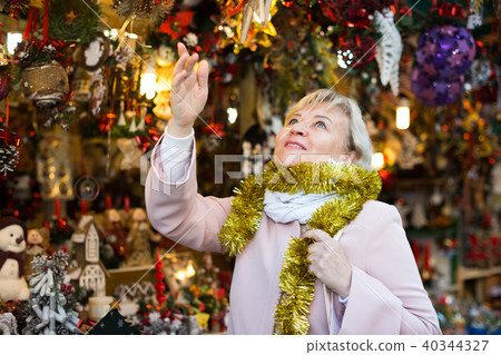 Positive female in tinsel on Christmas fair Positive female in tinsel on Christmas fair 40344327