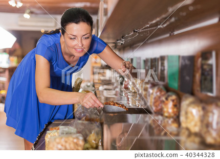 Woman taking nut beans in shop 40344328
