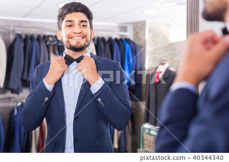 Male is trying on butterfly in front of the mirror Male is trying on butterfly in front of the mirror 40344340