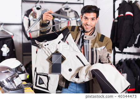 Male customer is choosing modern trousers in the sport store. Male customer is choosing modern trousers in the sport store. 40344473