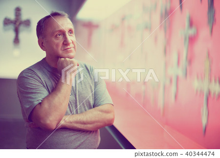 Portrait of thoughtful elderly man examining exposition in museum hall of applied arts 40344474