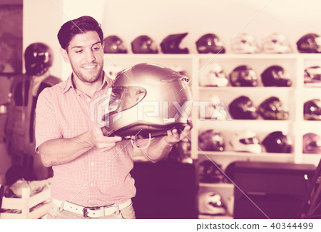 Man choosing moto helmet 40344499