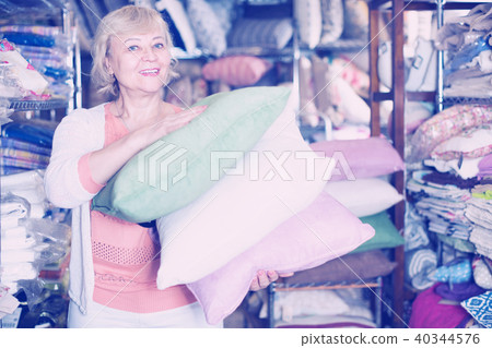 mature woman purchaser holding variety pillows mature woman purchaser holding variety pillows 40344576