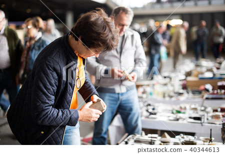 Woman buying retro handicrafts on indoor flea market Woman buying retro handicrafts on indoor flea market 40344613