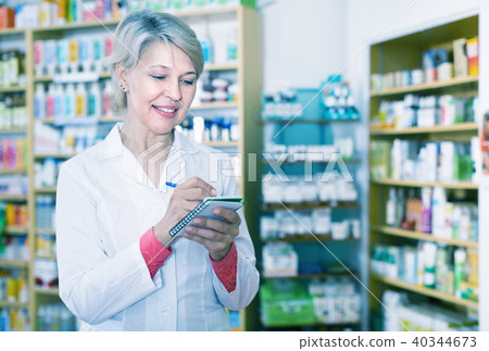 Female seller noting assortment in organic shop Female seller noting assortment in organic shop 40344673