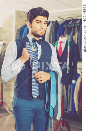 Person is picking up tie for waistcoat 40344868