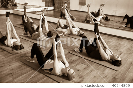 Young positive people stretching in dance hall Young positive people stretching in dance hall 40344869