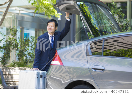 Businessman opening and closing car trunk Businessman opening and closing car trunk 40347521