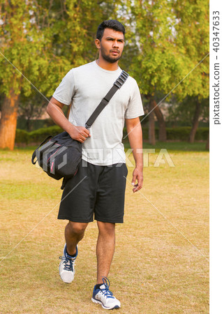 Young sportsman walking with sports bag Young sportsman walking with sports bag 40347633