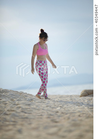 woman wearing sport suit walking on  sand beach 40349447