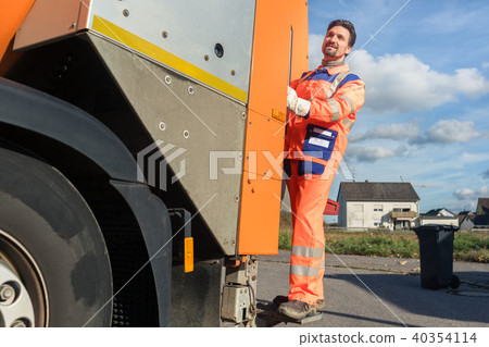 Garbage removal worker riding on the back of the disposal vehicle Garbage removal worker riding on the back of the disposal vehicle 40354114