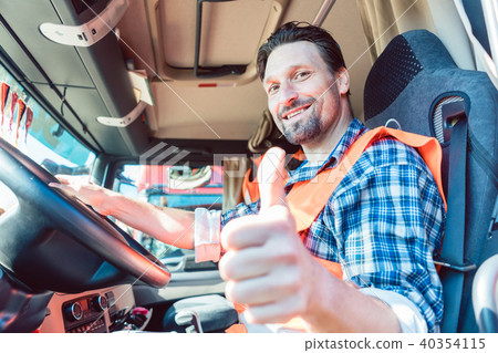 Truck driver sitting in cabin giving thumbs-up Truck driver sitting in cabin giving thumbs-up 40354115