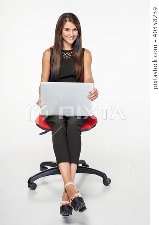 Business woman sitting on office chair working with laptop Business woman sitting on office chair working with laptop 40358239
