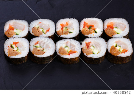Appetizing fresh maki sushi roll with omelet served on black sla Appetizing fresh maki sushi roll with omelet served on black sla 40358542