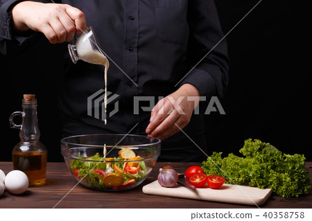 Chef pouring sauce on caesar salad, cooking process, restaurant Chef pouring sauce on caesar salad, cooking process, restaurant 40358758