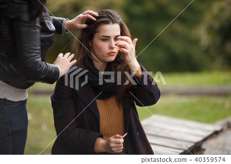 Assistant making model's hairstyle at the fashion shoot Assistant making model's hairstyle at the fashion shoot 40359574