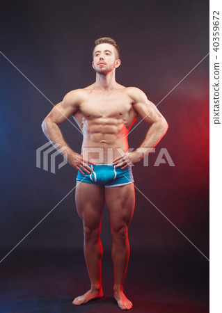 Young muscular ripped man bodybuilder demonstrating perfect body Young muscular ripped man bodybuilder demonstrating perfect body 40359672