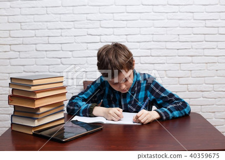 Diligent schoolboy writing down a task into a notebook. Elementa 40359675