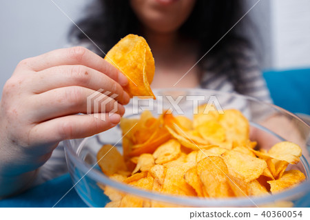 Fat woman reaching to chips. Unhealthy eating, bad habits, food Fat woman reaching to chips. Unhealthy eating, bad habits, food 40360054