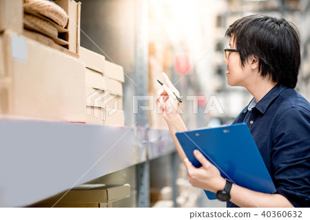 Young Asian man doing stocktaking in warehouse 40360632