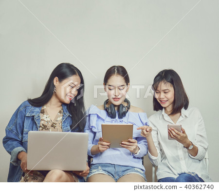 Women and friends. using phone and computer. 40362740