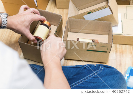 Employees are packing a parcel in the send. Employees are packing a parcel in the send. 40362742