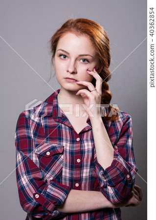 Young red-haired girl in a plaid shirt with finger 40362854