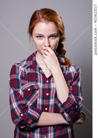 Young red-haired girl in a plaid shirt with finger 40362857
