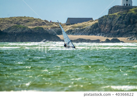 Wind surfer enjoys the beach at Newborough Warren with the Island of Llanddwyn in the background 40366622