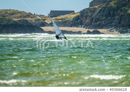 Wind surfer enjoys the beach at Newborough Warren with the Island of Llanddwyn in the background Wind surfer enjoys the beach at Newborough Warren with the Island of Llanddwyn in the background 40366628