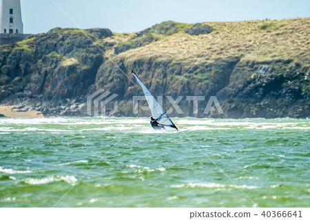 Wind surfer enjoys the beach at Newborough Warren with the Island of Llanddwyn in the background Wind surfer enjoys the beach at Newborough Warren with the Island of Llanddwyn in the background 40366641