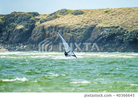 Wind surfer enjoys the beach at Newborough Warren with the Island of Llanddwyn in the background Wind surfer enjoys the beach at Newborough Warren with the Island of Llanddwyn in the background 40366645