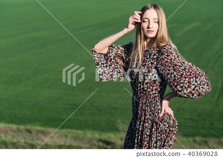 Beautiful girl in dress poses on rock in nature Beautiful girl in dress poses on rock in nature 40369028